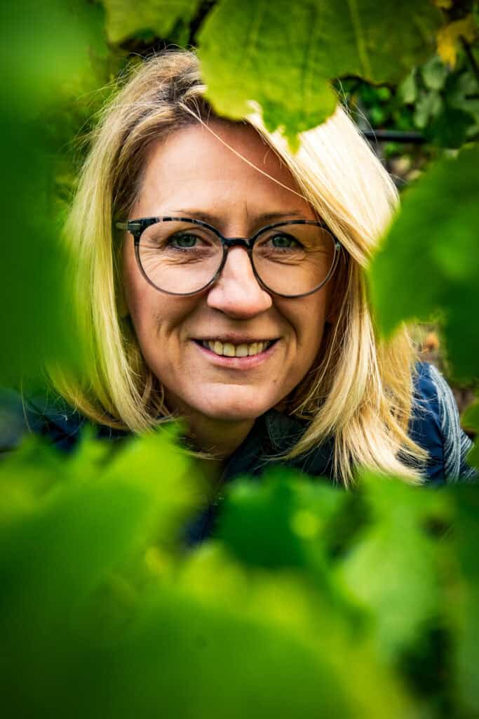 Leidenschaftliche Winzerin im Weinberg, die Qualität und Tradition verbindet.